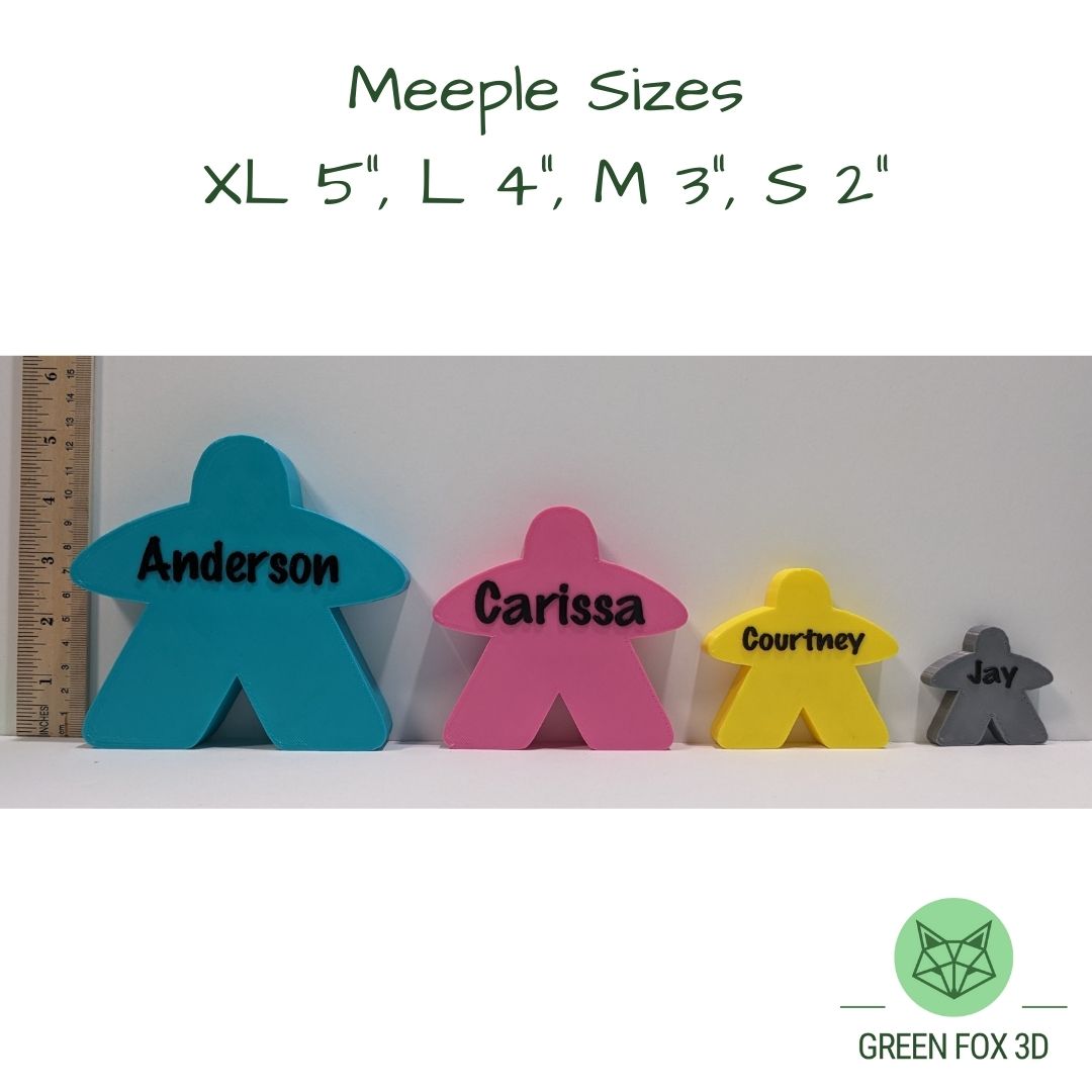 A comparison of various sized, personalized meeples against a ruler, decreasing in size.