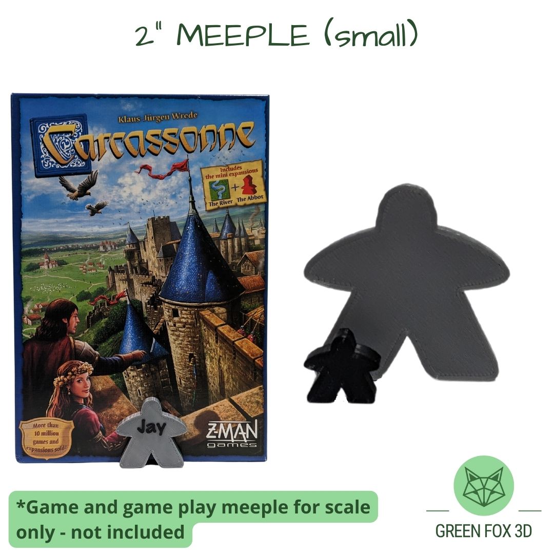A comparison of a personalized, 2 inch meeple against game token and board game box.